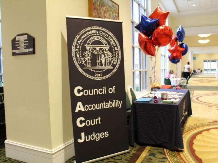 Table at the conference with balloons and a CACJ banner.